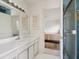 Bathroom featuring a vanity, mirror with lights, and a view into an adjacent bedroom at 1014 Contento St, Sarasota, FL 34242