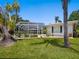 Exterior side view of the home featuring a screened in patio and lush lawn at 1014 Contento St, Sarasota, FL 34242