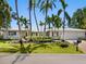 Inviting single-story home featuring manicured landscaping, a brick driveway, and mature tropical palm trees at 1014 Contento St, Sarasota, FL 34242