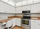 Kitchen featuring stainless steel appliances, wood floors, and white cabinetry at 1014 Contento St, Sarasota, FL 34242