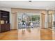Bright, open-concept living space with hardwood floors, mirrored wall, and a view of the screened-in pool area at 1014 Contento St, Sarasota, FL 34242