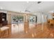 Bright living room with gleaming hardwood floors, a mirrored wall, and sliding glass doors to the pool area at 1014 Contento St, Sarasota, FL 34242