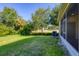 A spacious backyard with lush grass and tropical landscaping at 1033 Grantham Dr, Sarasota, FL 34234