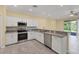 Bright kitchen with white cabinets, granite counters, stainless steel appliances and tile floors, with an open floorplan at 1033 Grantham Dr, Sarasota, FL 34234