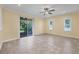 A bright and airy living room with tile floors and a ceiling fan, with sliding glass door to an outdoor area at 1033 Grantham Dr, Sarasota, FL 34234