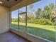 A screened in lanai providing a view of the spacious backyard with tropical landscaping at 1033 Grantham Dr, Sarasota, FL 34234