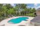 Community pool surrounded by mature trees and landscaping creating a private oasis at 1033 Grantham Dr, Sarasota, FL 34234