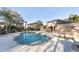 Community pool and hot tub area with lounge chairs and tables for relaxing by the water at 1033 Grantham Dr, Sarasota, FL 34234
