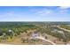 Aerial view of a modern home with a pond in the front yard and a surrounding wooded area at 1116 406Th E Ct, Myakka City, FL 34251