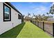Backyard featuring new artificial turf and a black metal fence surrounding the property at 1116 406Th E Ct, Myakka City, FL 34251