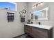 Modern bathroom featuring a sleek vanity, illuminated mirror, and decorative towel racks at 1116 406Th E Ct, Myakka City, FL 34251