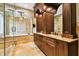 Luxurious bathroom features double vanity with granite countertops and a glass-enclosed tub with marbled tile at 11504 Splendid Ln, Tampa, FL 33626
