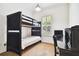 Bright bedroom featuring a bunk bed, a writing desk, and a window with plantation shutters at 11504 Splendid Ln, Tampa, FL 33626