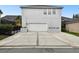 Neutral two-story home featuring a large garage door, planter boxes, and a wide driveway, providing curb appeal and practicality at 11504 Splendid Ln, Tampa, FL 33626