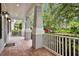 Spacious front porch with brick flooring, columns, and a white railing overlooking the lawn at 11504 Splendid Ln, Tampa, FL 33626