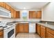 Cozy kitchen with oak cabinets, white appliances, speckled countertops and tile flooring at 11504 Splendid Ln, Tampa, FL 33626