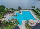 Aerial view of a community pool with a beach entry, lap lanes, lounge chairs, and lakeside views, creating a resort-like atmosphere at 11504 Splendid Ln, Tampa, FL 33626