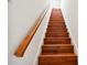A well-lit staircase featuring hardwood treads, white risers, and a stained wood handrail leading upwards at 11504 Splendid Ln, Tampa, FL 33626