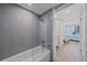 Bathtub with a tile surround and glass partition open to bedroom at 1212 Benjamin Franklin Dr # 306, Sarasota, FL 34236