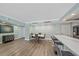 Dining area with a white table, comfortable seating, and a view of the kitchen at 1212 Benjamin Franklin Dr # 306, Sarasota, FL 34236