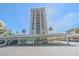 Luxury high rise condominium with covered parking with beautiful palm trees, blue skies, and lush landscaping at 1212 Benjamin Franklin Dr # 306, Sarasota, FL 34236