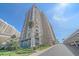 Upscale condo tower with multiple floors and balconies under a clear blue sky with lush landscaping at 1212 Benjamin Franklin Dr # 306, Sarasota, FL 34236