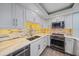 Well-equipped kitchen with stainless steel appliances, quartz countertops, and modern backsplash at 1212 Benjamin Franklin Dr # 306, Sarasota, FL 34236