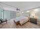 Bright main bedroom features a ceiling fan, bench, and luxury vinyl plank flooring at 1212 Benjamin Franklin Dr # 306, Sarasota, FL 34236