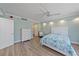 Bright bedroom featuring wood-look floors, a white ceiling fan, and ensuite bathroom at 1212 Benjamin Franklin Dr # 306, Sarasota, FL 34236