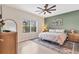 Comfortable bedroom featuring a ceiling fan, queen bed, accent wall and great natural light at 12237 Longview Lake Cir, Bradenton, FL 34211