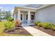 Inviting front entrance featuring a covered porch, manicured landscaping, and a welcoming pathway at 12237 Longview Lake Cir, Bradenton, FL 34211
