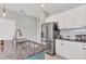 Granite kitchen island with stainless steel refrigerator, white cabinets, and subway tile backsplash at 12237 Longview Lake Cir, Bradenton, FL 34211
