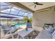 Beautiful screened patio features modern furniture, ceiling fan, and an amazing view of the pool and lake at 12237 Longview Lake Cir, Bradenton, FL 34211