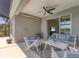 This patio features a ceiling fan, cozy seating, and view to the indoor living space and outdoor landscape at 12237 Longview Lake Cir, Bradenton, FL 34211
