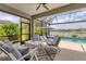 Relaxing screened patio with comfortable seating and a view of the pool, spa, and waterfront at 12237 Longview Lake Cir, Bradenton, FL 34211