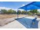 Community playground area featuring a blue awning covered seating with benches, with a grassy, treed area in the background at 12237 Longview Lake Cir, Bradenton, FL 34211