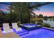 A luxurious pool and spa create a peaceful retreat with lights and a scenic view of the water at 12237 Longview Lake Cir, Bradenton, FL 34211