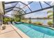Screened in pool and hot tub with lake view, lounge chairs and an umbrella at 12237 Longview Lake Cir, Bradenton, FL 34211