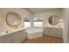 Luxurious bathroom with double vanities, a soaking tub, and ample natural light from large windows at 12541 Estrella Blvd, Punta Gorda, FL 33955