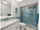 Stylish bathroom showcasing a sleek glass-enclosed shower with blue tile surround and modern fixtures at 1302 58Th W St, Bradenton, FL 34209