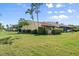 Well-maintained exterior with lush greenery, red tile roof, and well manicured lawn at 1302 58Th W St, Bradenton, FL 34209