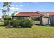 Attractive house showcasing a red tile roof and a neatly manicured lawn with green hedges at 1302 58Th W St, Bradenton, FL 34209