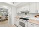 Bright kitchen featuring white cabinetry, tile backsplash, laminate countertops, and standard appliances at 1302 58Th W St, Bradenton, FL 34209