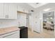 Bright kitchen featuring white cabinets, tile backsplash, tan countertops and a mini refrigerator at 1302 58Th W St, Bradenton, FL 34209