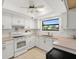 Well-lit kitchen with white cabinets, neutral countertops, tile backsplash, and standard appliances at 1302 58Th W St, Bradenton, FL 34209