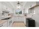 Bright kitchen featuring white cabinets, stone countertops, tile flooring, and modern appliances at 1302 58Th W St, Bradenton, FL 34209
