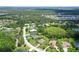 Aerial view of a well-manicured home with a brick driveway in a mature tree lined neighborhood at 15608 31St E St, Parrish, FL 34219