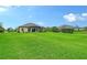 Large grassy backyard with a screened-in lanai, offering ample outdoor space and privacy at 15608 31St E St, Parrish, FL 34219
