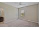 A bright bedroom with a neutral carpet, ceiling fan, and view to the vanity sink in the en suite bathroom at 15608 31St E St, Parrish, FL 34219