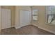 A comfortable bedroom with a closet, wood-look floors, and natural light from two windows at 15608 31St E St, Parrish, FL 34219